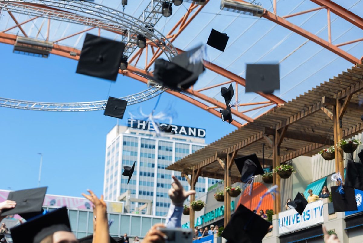 Rockhurst University graduates throw their caps at the Power & Light District on May 15, 2024. Photo provided by Rockhurst Marketing.